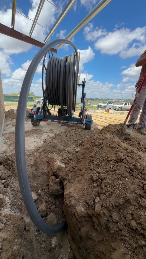 HDPE pipe pullback into a trench at a commercial construction site