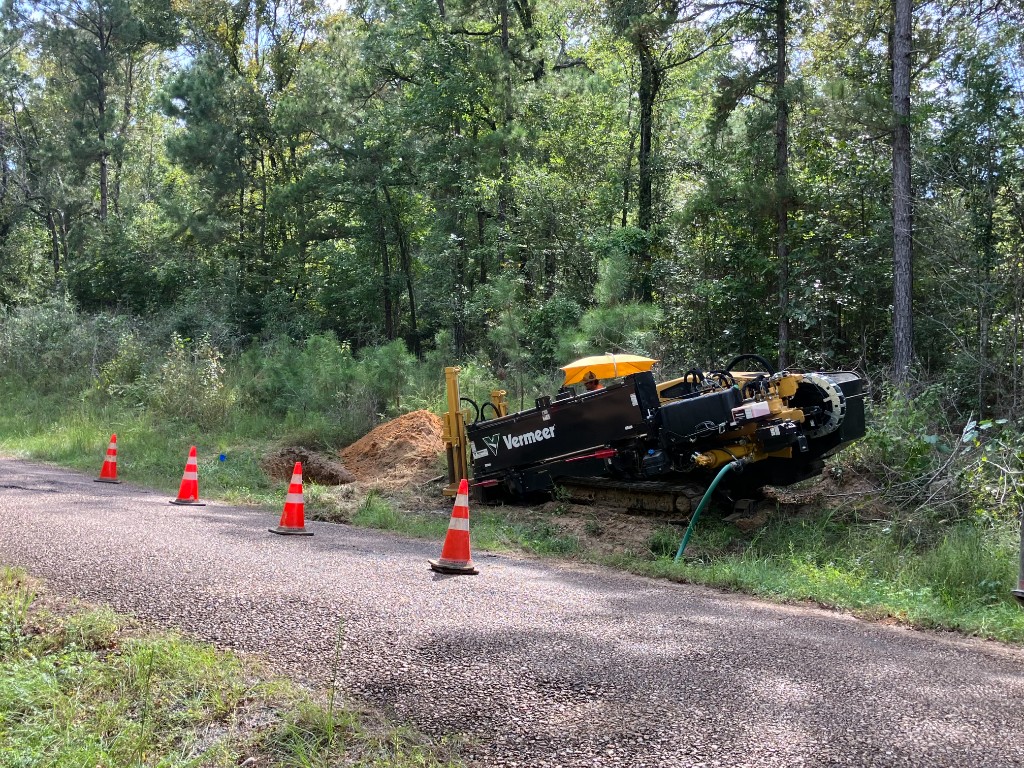 Vermeer horizontal directional drill staged at a wooded utility job site